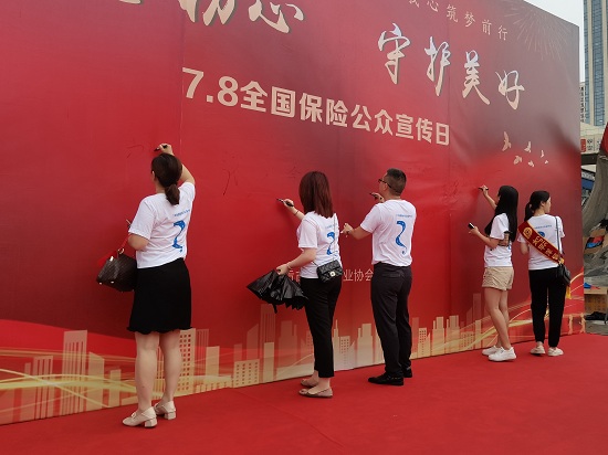 从业人员在主题背景签名墙上签名