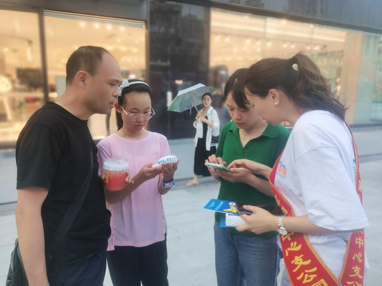 群众在工作人员指导下关注“贡家保”公众号，了解产品特点